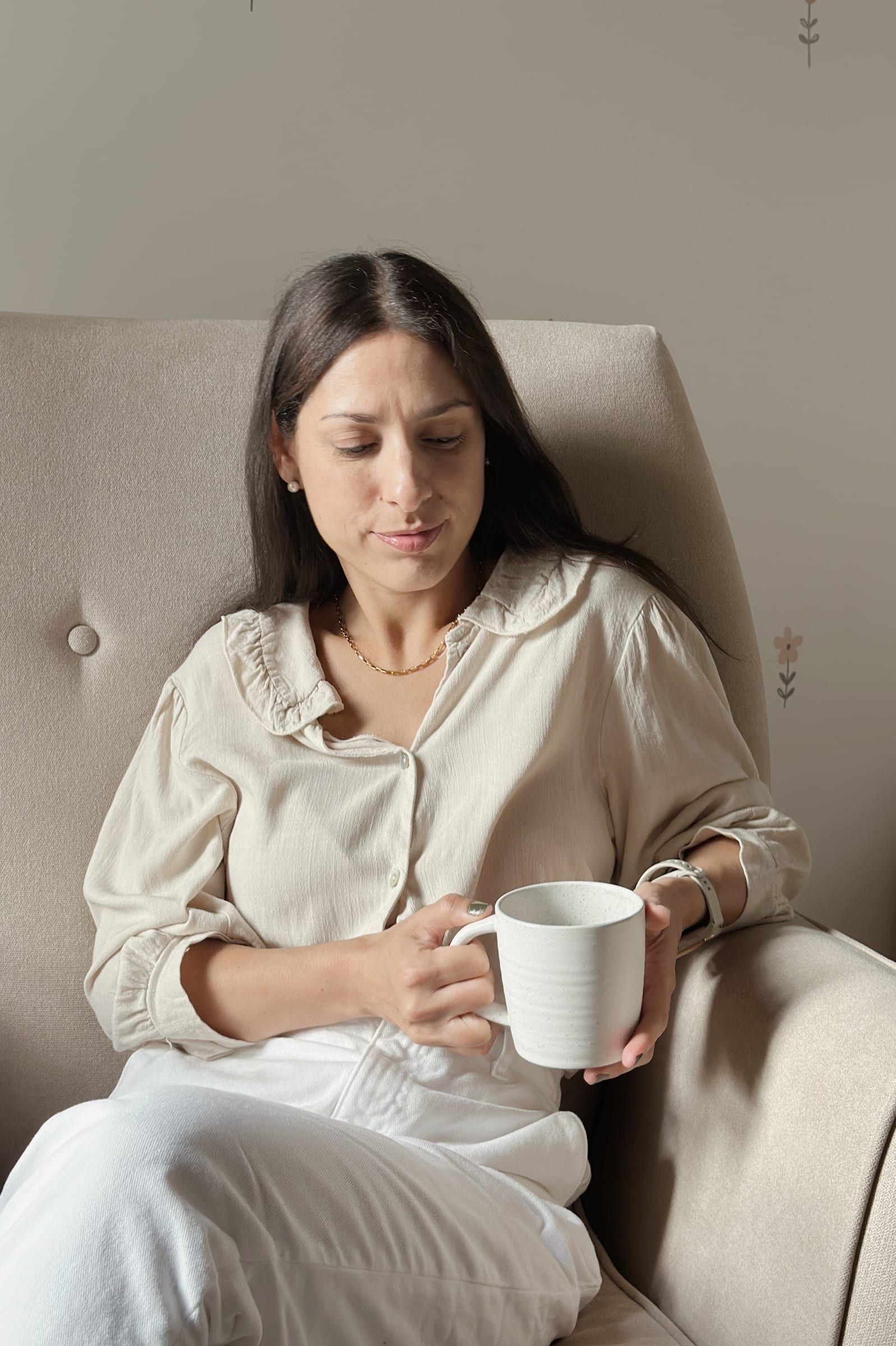 Mujer disfrutando una taza de té en un sillón