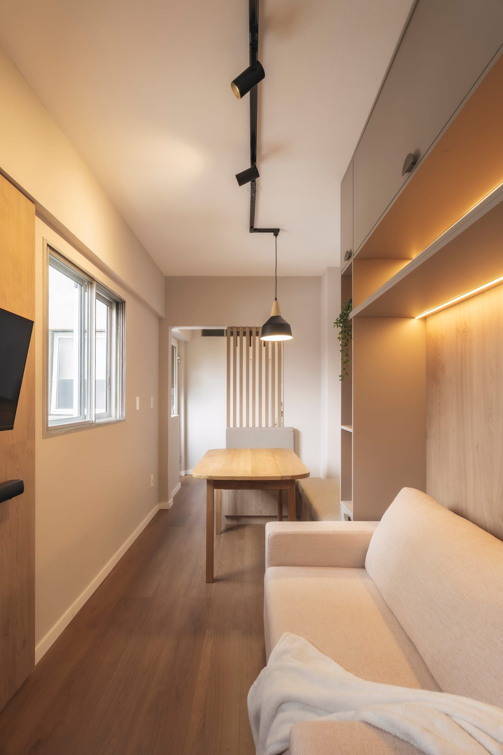 Living con ventana, mesa de madera y sofá claro