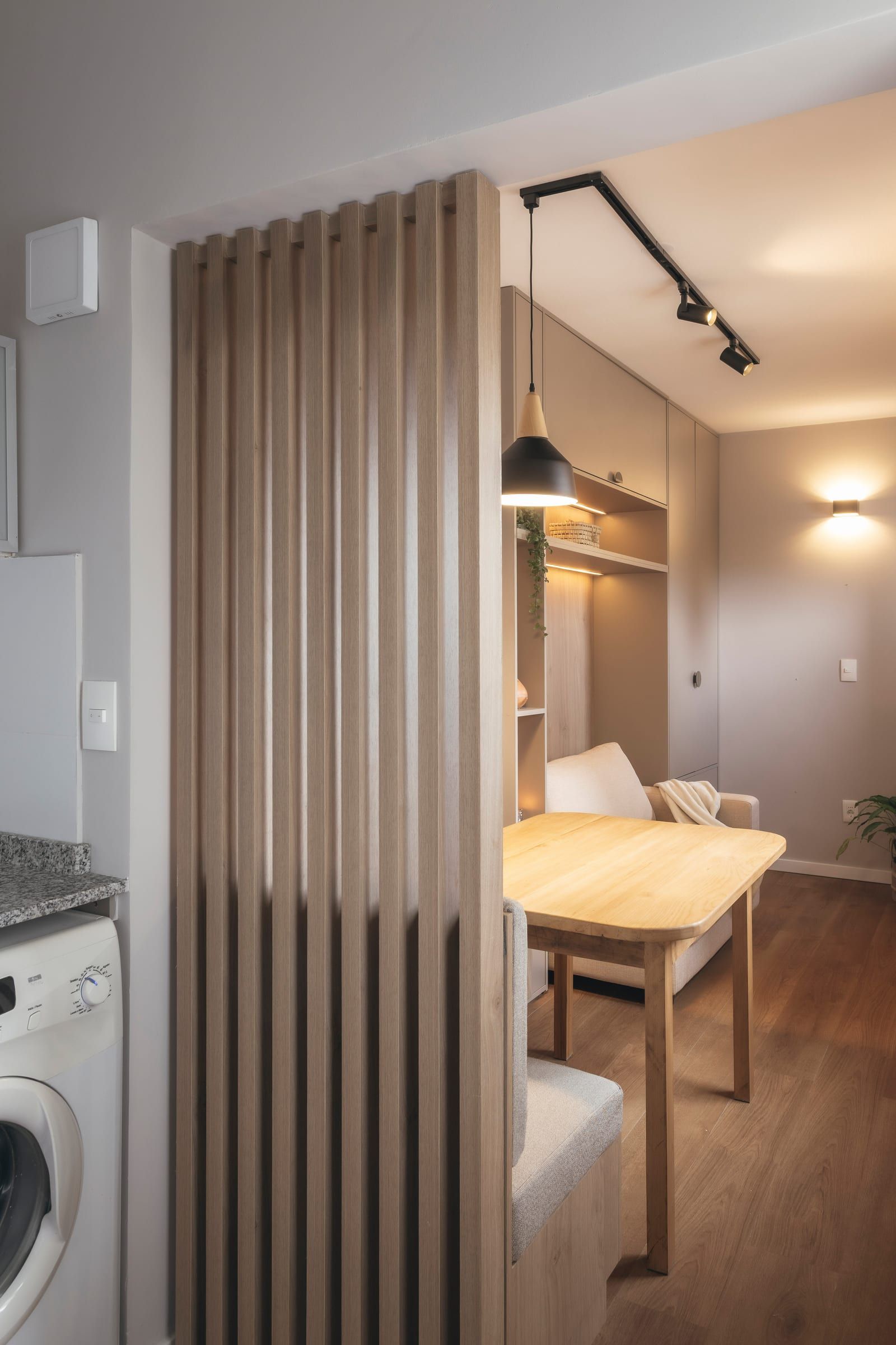 Divisor de listones de madera que integra el comedor al living